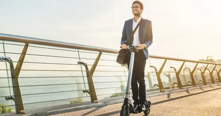 Homme en trottinette électrique se rendant au travail en ville